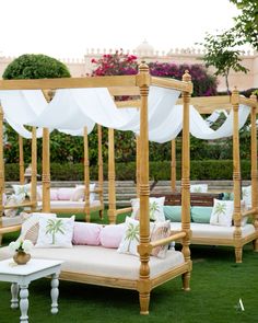 an outdoor seating area with white drapes and pillows