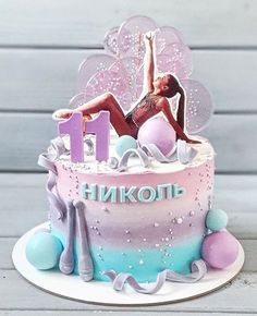 a birthday cake with a woman on top and decorations around the bottom that spell out 11