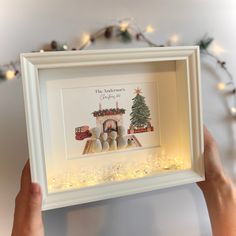 someone is holding up a framed christmas card