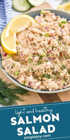 salmon salad in a bowl with lemon wedges and dill garnish on the side