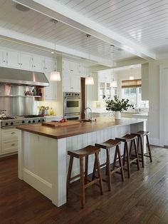 a kitchen island with stools in front of it and an open floor plan on the wall