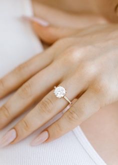 a woman's hand with a diamond ring on her left hand and the words moosantee center stone affixed to it