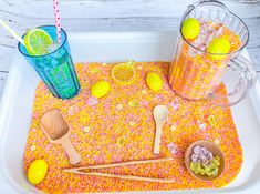 a tray with lemons, sprinkles and wooden spoons on it