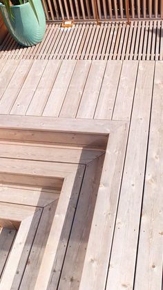 a wooden deck with potted plants next to it