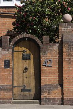 a brick building with a wooden door and number 42 on the front entrance to it