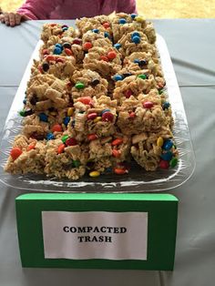 a child sitting at a table in front of a tray full of cereal krispy treats