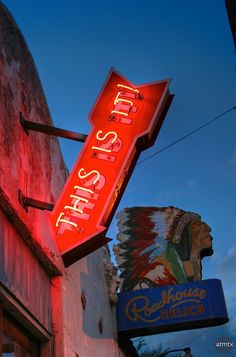 a neon sign that is on the side of a building