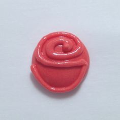 a red button with a spiral design on it