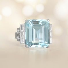 This stunning aquamarine ring showcases a magnificent approx 10.55-carat emerald cut aquamarine, held securely by the prongs. On both sides of the center stone, there are baguette-cut diamonds . The curved shoulders of the ring have old mine-cut diamonds, totaling approximately 1.20 carats. Handcrafted, the ring is made of platinum and features an intricate geometric design. ✦ GEMSTONE SPECIFICATIONS:    Aquamarine Weight: Approx 10.55 Carats  Aquamarine Cut: Emerald Cut  Total Diamond Weight: A Luxury Aquamarine Diamond Ring With Prong Setting, Luxury Gia Certified Aquamarine Ring, Luxury Light Blue Rings For Anniversary, Formal Light Blue Aquamarine Diamond Ring, Elegant Aquamarine Ring With Vvs Clarity, Elegant Aquamarine Rings With Vvs Clarity, Luxury Aquamarine Diamond Ring Gift, Elegant Light Blue Aquamarine Diamond Ring, Luxury Light Blue Topaz Ring For Anniversary