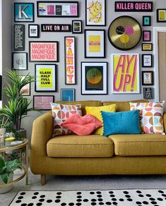 a living room filled with lots of different types of pillows and pictures on the wall