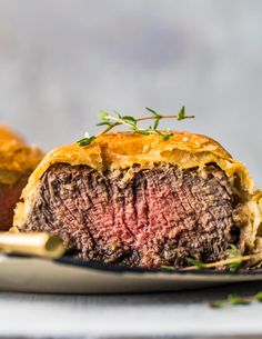 a close up of a meatloaf roll on a plate next to a fork