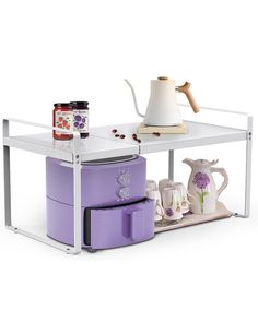 a white table topped with purple appliances and pots