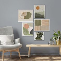 a living room with grey walls and pictures on the wall, two chairs and a coffee table