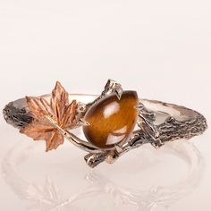 "A handmade 14k twig and leaf ring made in two gold colors and set with a high-quality tiger's eye. The tiger's eye is a 100% natural gem that is cut into a pear shape and measures 5mx7mm. The grooves in the band are plated with black rhodium which emphasizes the texture. if you prefer not to apply the black rhodium that is fine. I can also use white, rose, or yellow gold for the band and the leaves for the same price. If you are looking at this ring then you are probably looking for something s Tiger Eye Engagement Ring, Animal Engagement Ring, Tigers Eye Wedding Ring, Leaf Ring Engagement, Nature-inspired Rings With Polished Finish, Eye Engagement Ring, Maximalist Wedding, Animal Rings Jewelry, Fox Ring