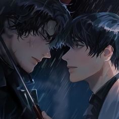 two young men standing next to each other in the rain