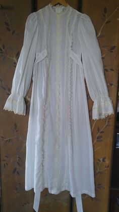 "70's so gorgeous boho wedding / hippie / maxi prairie dress. Semi sheer light ivory with tiny tan polka dots fabric. Crochet cream flower lace detail down the front, around neck and at ends of flared cuffs. End of sleeves are elasticated just above the wide cuffs. Two long ties at sides of bust and buttons up the back. **Back of neck lace trim has some bleaching on the cream crochet and tiny bleach spot at bottom of trim on front but barely visible.** Such a unique and gorgeous dress! Made by C Cream Victorian Dress For Spring, Spring Cream Victorian Dress, Bohemian Dresses With Lace Sleeves For Daywear, Vintage Spring Dresses With Lace Cuffs, Spring Vintage Dress With Lace Cuffs, Vintage Dresses With Lace Cuffs For Spring, Vintage Flowy Long Maxi Dress, Bohemian Prairie Dress With Ruffles In Maxi Length, Spring Victorian Dress With Lace Trim In Vintage White