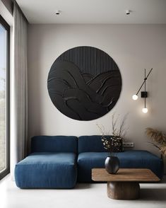 a living room with a blue couch and large circular wall art