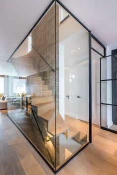 the interior of a house with glass walls and stairs