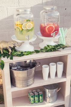 an outdoor bar with lemonade, water and limes on it's shelves