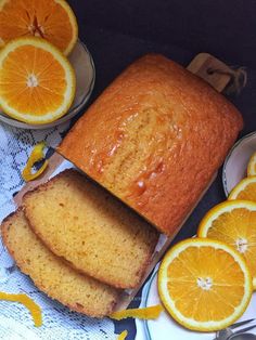 slices of orange bread on plates next to sliced oranges