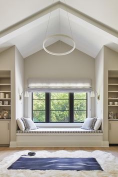 a window seat in the middle of a room with built - in bookshelves