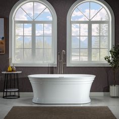 a large white bath tub sitting next to two windows