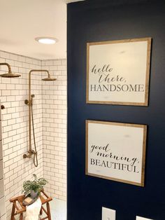 the bathroom is decorated in navy blue and white with gold accents, including two framed signs