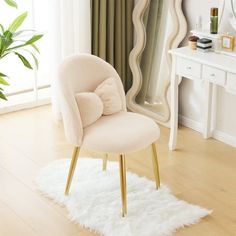 a white chair sitting in front of a mirror on top of a hard wood floor