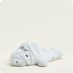 a stuffed hippo laying on the ground with it's head turned to the side