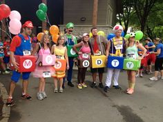 a group of people dressed up as mario and luigi for a race event with balloons on their heads