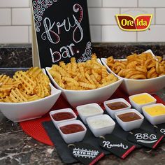 several bowls filled with fries and dips next to a sign that says ketchup bar