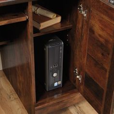 a computer tower sitting inside of a wooden cabinet