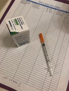 a pen sitting on top of a piece of paper next to a carton of medicine