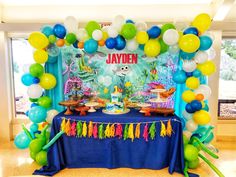 an under the sea themed birthday party with balloons and streamers in blue, green, yellow and white colors