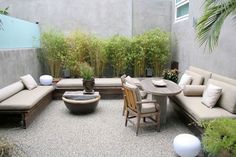 an outdoor patio with couches, tables and potted plants