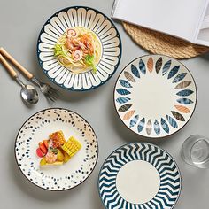 four plates with different designs on them next to utensils