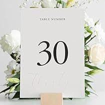 a table number is placed next to a bouquet of flowers