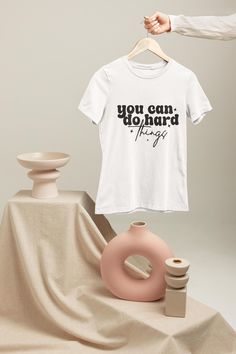 You Can Do Hard Things Shirt, Motivational Quote Tee ✨👕 Welcome to STRONGTEECRAFT! We specialize in bringing your unique style to life using our top-notch DTF or DTG printing technology. With standard unisex sizes available, we guarantee a perfect fit for everyone. Want a looser fit? Just order one size up! If you have any sizing questions, our team is available 24/7 to assist you. 👆 Tips Before Ordering: Make sure to check all the details. Start by selecting your size, then choose a color from our extensive selection. For a relaxed, oversized look, consider sizing up. Don't forget to refer to our color chart for guidance. 🔄 Adding More Items: To purchase additional items, place the current product in your cart, go back, and repeat the selection process. 🌈 Pattern Information: Some pat Do Hard Things, Quote Tees, Graphic Apparel, Unique Shirt, Positive Messages, Dtg Printing, You Can, Motivational Quote, You Can Do