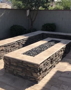 a stone fire pit in the middle of a patio