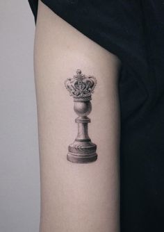 a black and white photo of a chess piece on the right arm with a crown on it