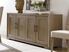 a sideboard with two chairs and a mirror on it in a white living room