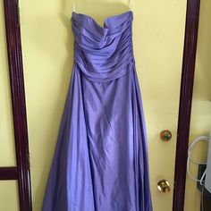 a purple dress hanging up on a door