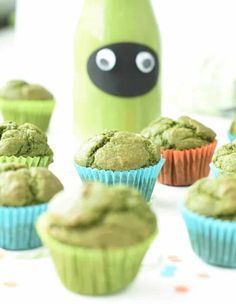 cupcakes with green frosting and a bottle of milk in the back ground