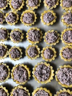 many small pastries are lined up on a baking sheet and ready to be baked