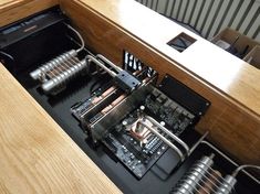 the inside of a computer case with many wires and components attached to it, sitting on top of a wooden table