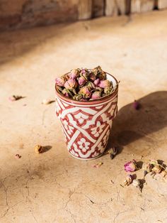 a red and white cup filled with dried flowers