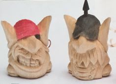 two wooden carved figurines with red bandanas on their heads