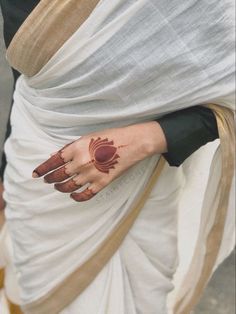 a close up of a person's hand with henna on her left arm