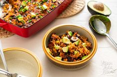 two bowls filled with food next to an avocado and rice dish on a table