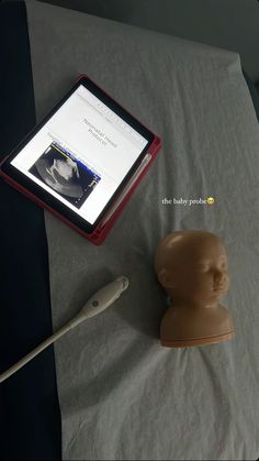 an electronic device sitting on top of a table next to a dummy head and tablet